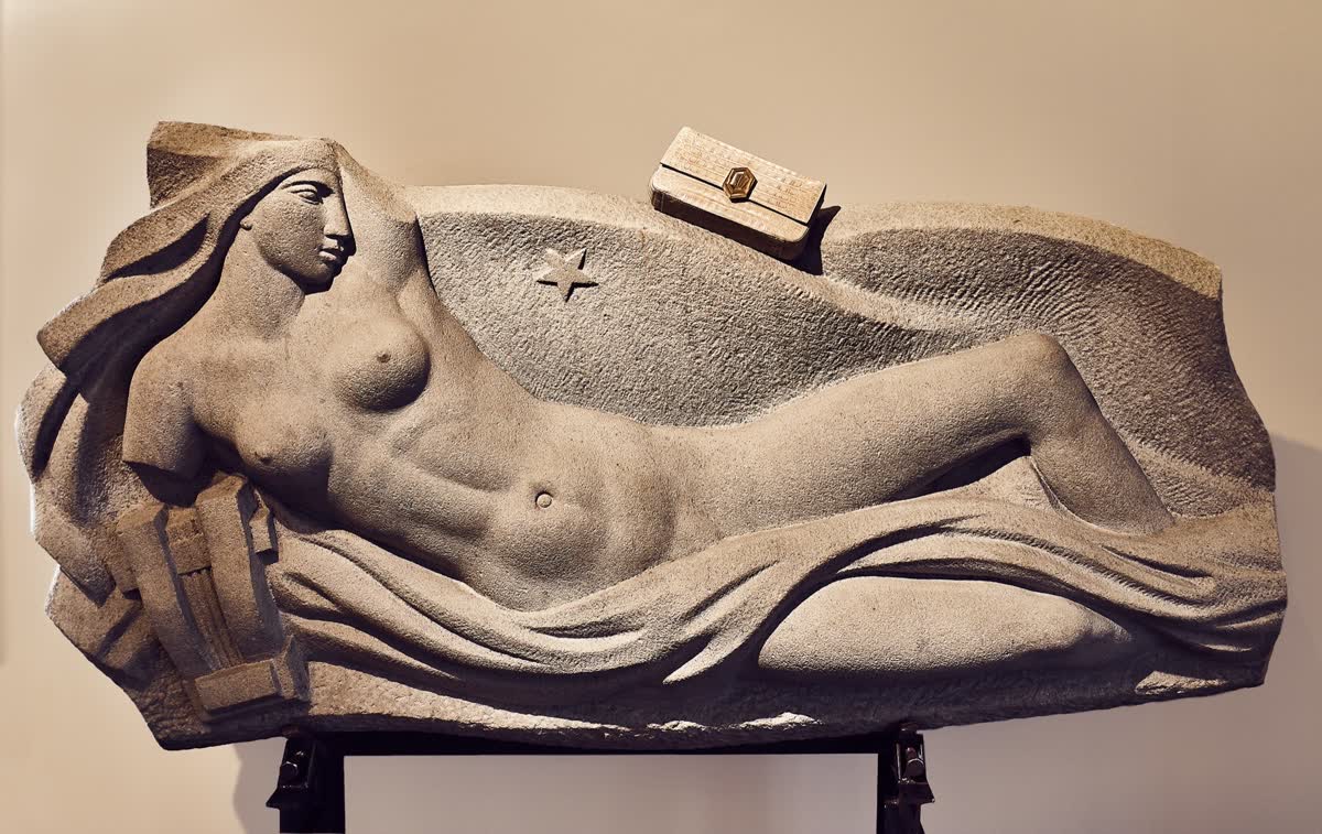 Pieza de la campaña apoyada sobre una escultura reclinada